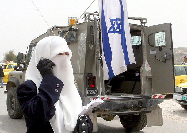 Una mujer palestina habla por teléfono junto a un vehículo militar israelí (Nablus, Cisjordania. 2008) Una mujer palestina habla por teléfono junto a un vehículo militar israelí (Nablus, Cisjordania. 2008)