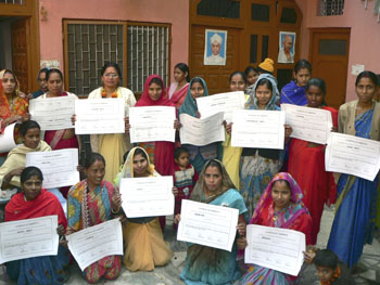 Grupo de mujeres muestran los diplomas en costura y bisutería, Nueva Delhi (La India, 2010)